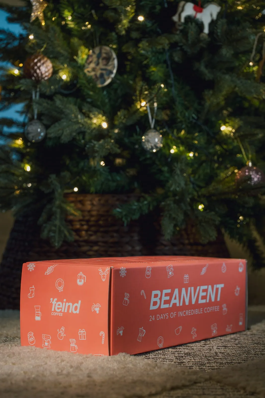Beanvent coffee advent calendar box glowing in front of a lit Christmas tree