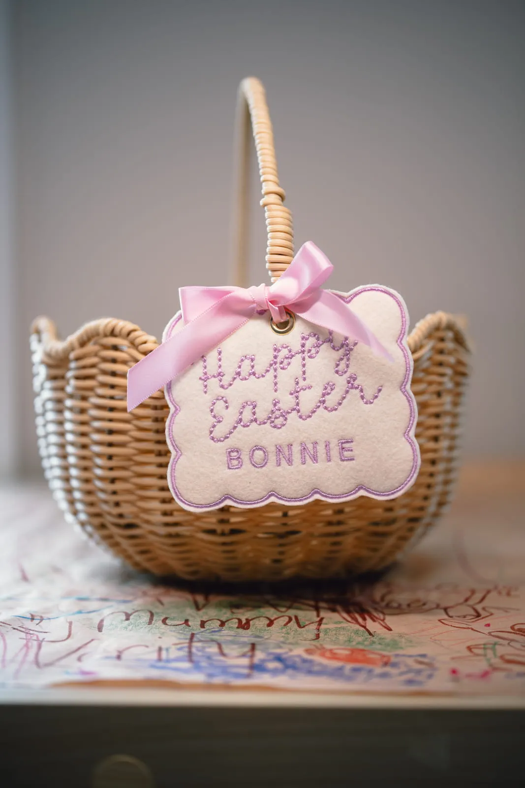 Wicker Easter basket with a personalised Happy Easter Bonnie embroidered tag with a pink satin bow